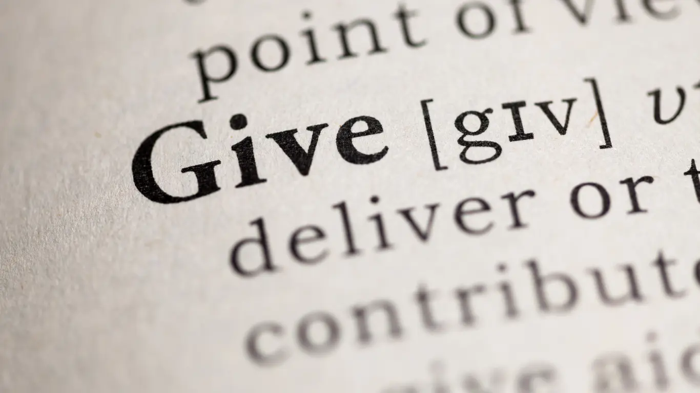 A person signing a charitable gift letter at a desk