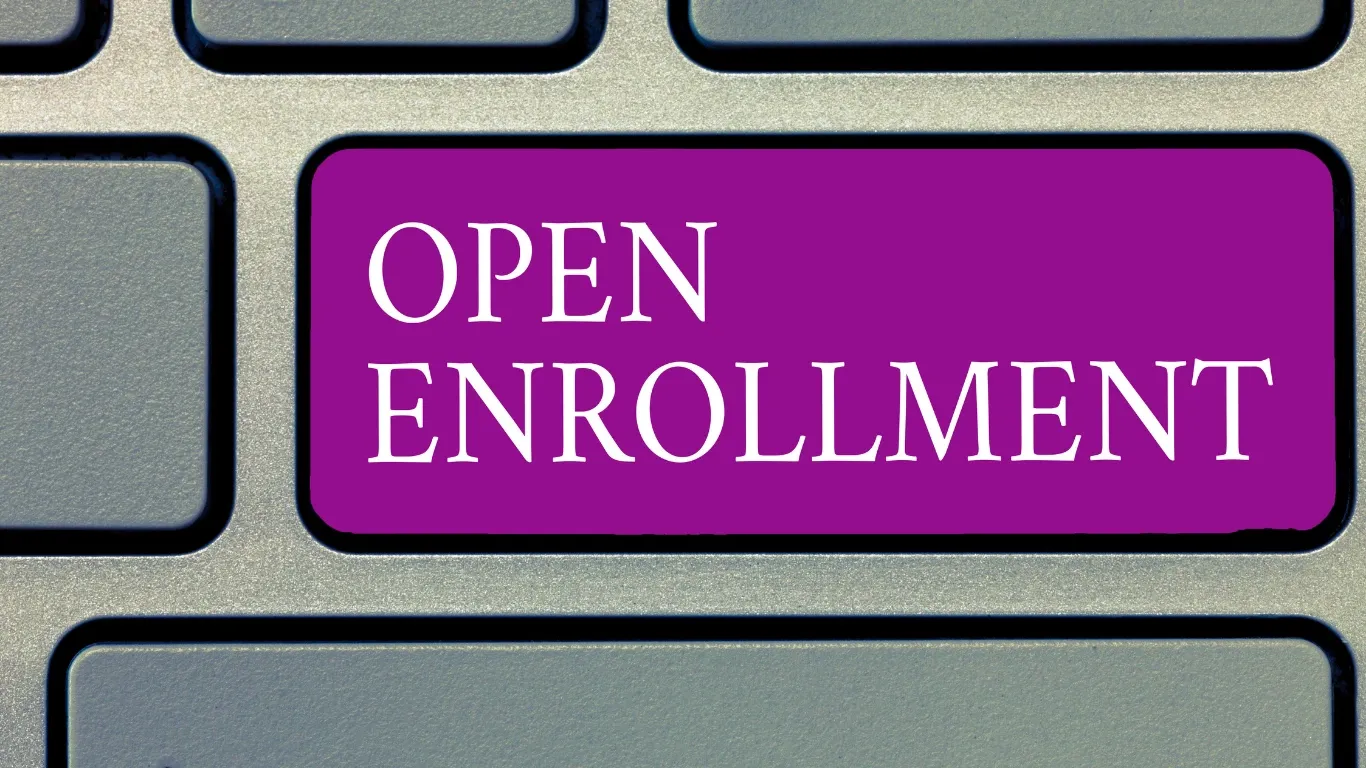 A purple keyboard key with the words Open Enrollment